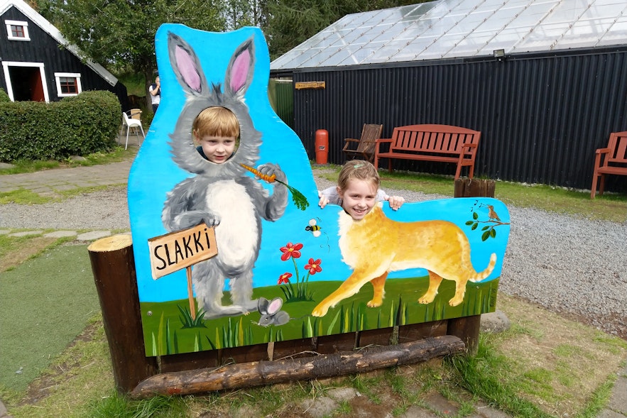 Two children with their heads through a character board at Slakki Petting Zoo.