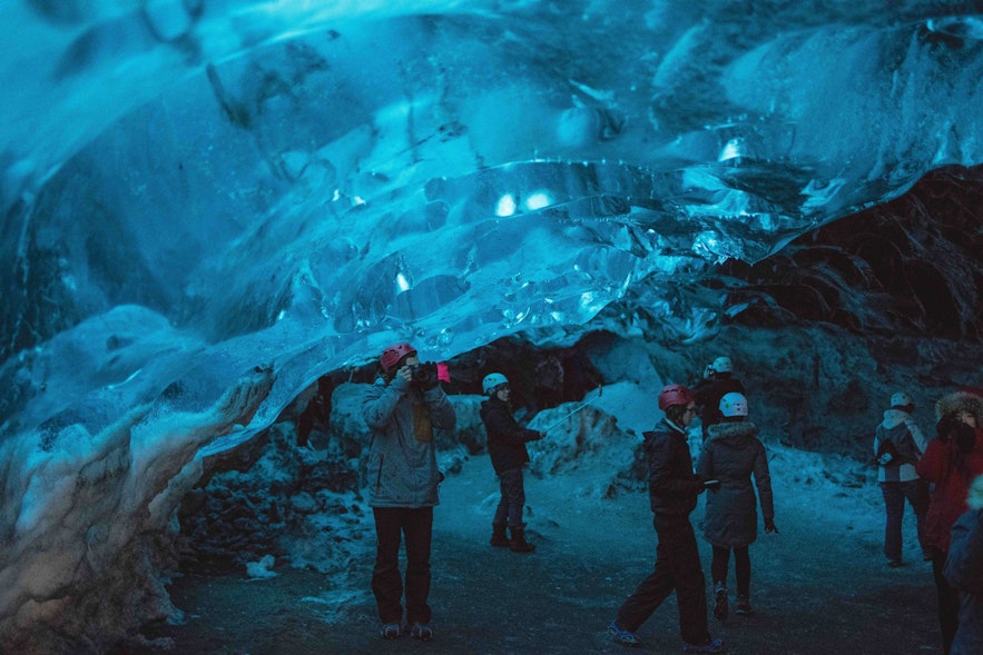 Tourists exploring an ice cave in Iceland.