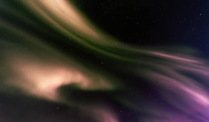 Purples and creams from the aurora borealis create a magical scene in the dark starry sky.