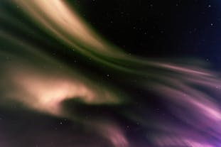 Purples and creams from the aurora borealis create a magical scene in the dark starry sky.