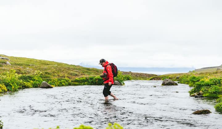 A hiker wades through the water during a 12-hour hike at the Hornstrandir Nature Reserve in the Westfjords.