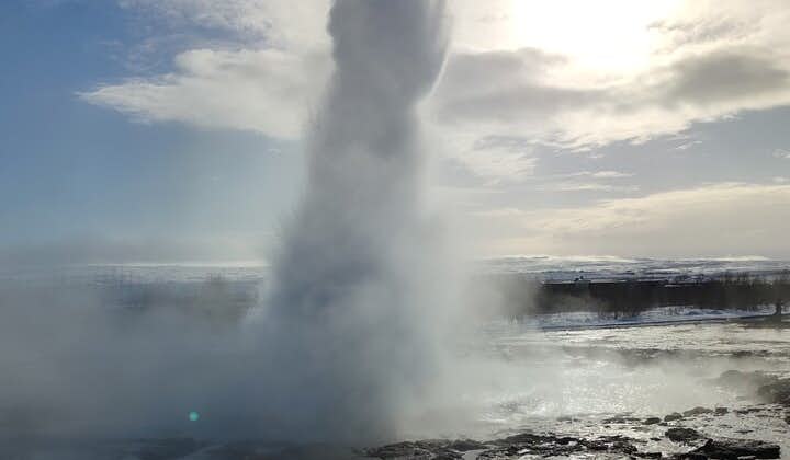 The Strokkur geyser at the Geysir geothermal area produces an impressive water display high into the air.