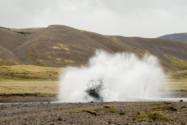 A buggy splashes through water as it drives through the terrain of the Icelandic Highlands.