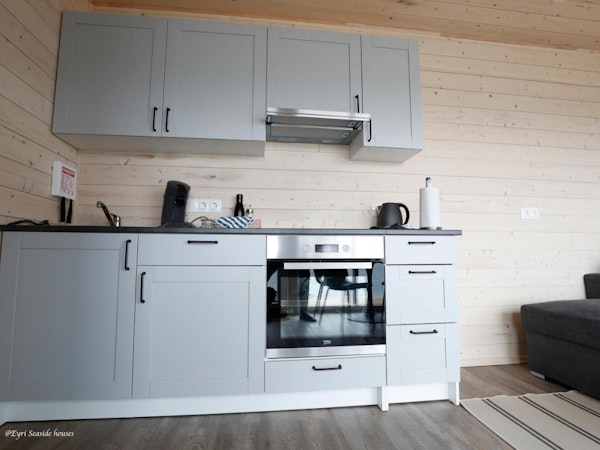 A modern kitchen with an oven at Eyri Seaside Houses in Northwest Iceland.