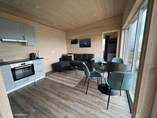A modern open-plan kitchen, dining, and living area at Eyri Seaside Houses in Northwest Iceland.