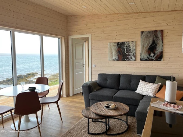 A modern, open-plan living area with lovely sea views at Eyri Seaside Houses in Northwest Iceland.