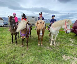 Los niños montan felices sus caballos y se preparan para su paseo a caballo.