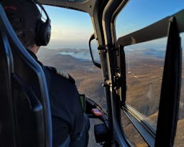 An expert pilot driving a helicopter over Iceland.