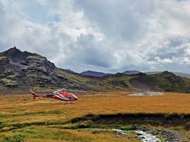 A helicopter makes a landing at Hengill geothermal area.