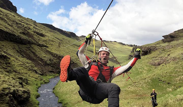 A participant on this exciting ziplining tour zooms across a river.
