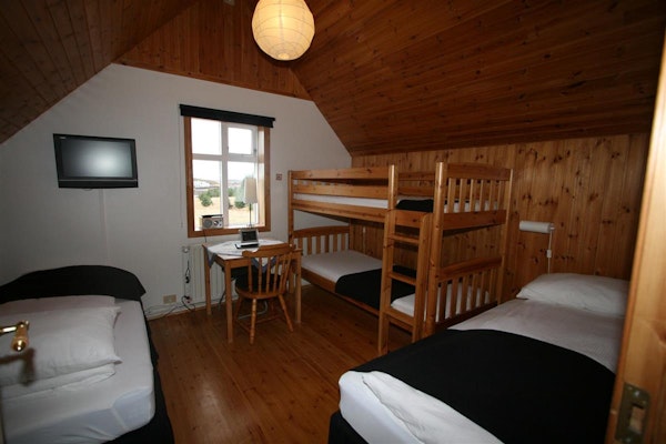 A family room at the Bjarg Borgarnes guesthouse, with two twin beds and a set of bunk beds.