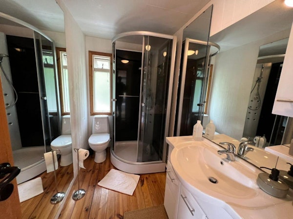 The Eyja Mörk private bathroom has a toilet, sink and vanity, and a shower.