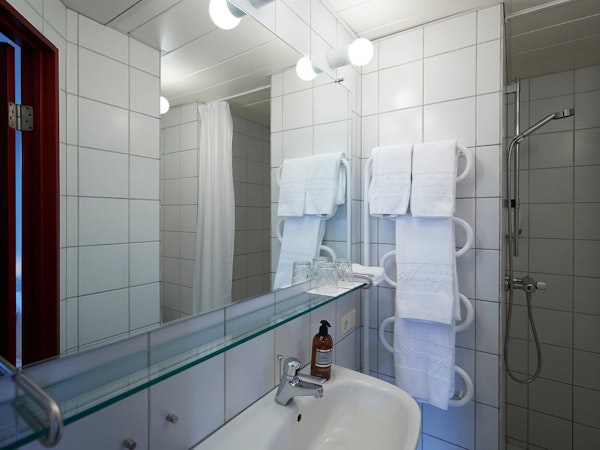 Hotel Akureyri Skjaldborg's bathroom includes towels, and complete with a shower and toilet.