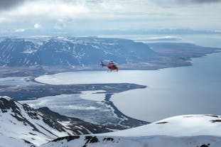 A helicopter flying back over the mountains in North Iceland.