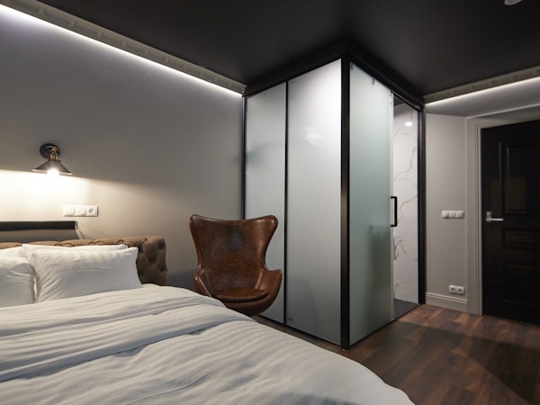 A thoughtfully designed tiny room at Hotel Akureyri Dynheimar in central Akureyri with a private shower and a chair next to the 