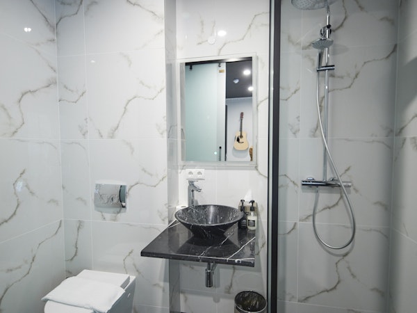 A thoughtfully designed modern bathroom in a superior double room at Hotel Akureyri Dynheimar in central Akureyri, with a glimps