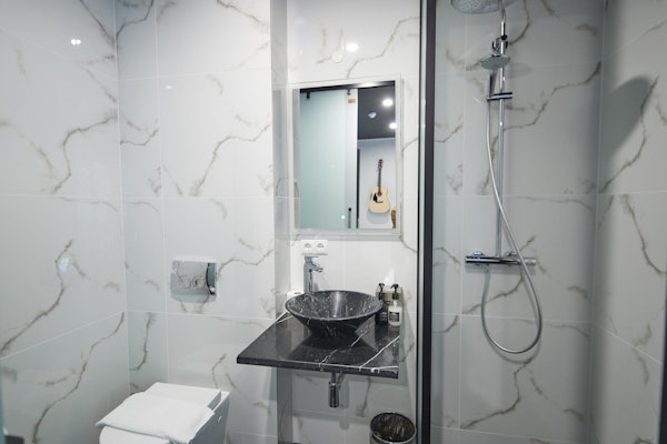 A thoughtfully designed modern bathroom in a superior double room at Hotel Akureyri Dynheimar in central Akureyri, with a glimps