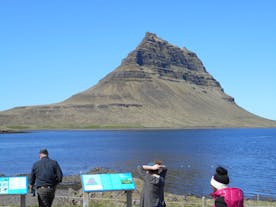 Sightseers look at a mountain on the Snaefellsnes Peninsula in summer.