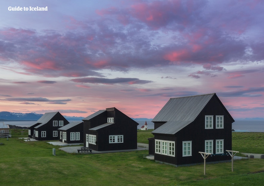 The black houses in Hellnar village on the Snaefellsnes peninsula produce a striking contrast against the colorful sky.