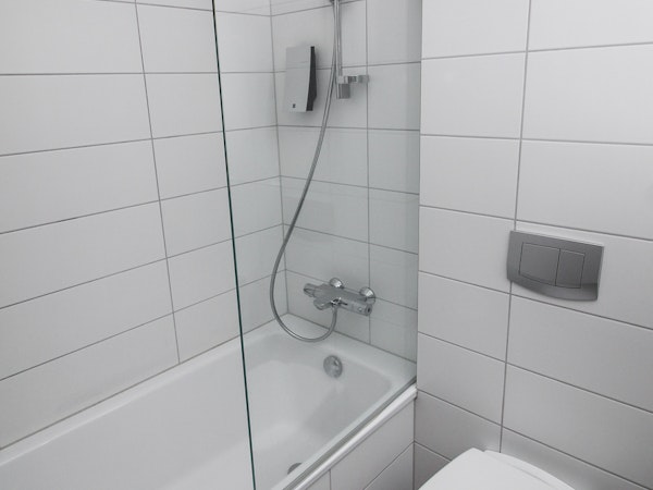 A bathroom in Bella Hotel, Selfoss, featuring a shower above a bath.