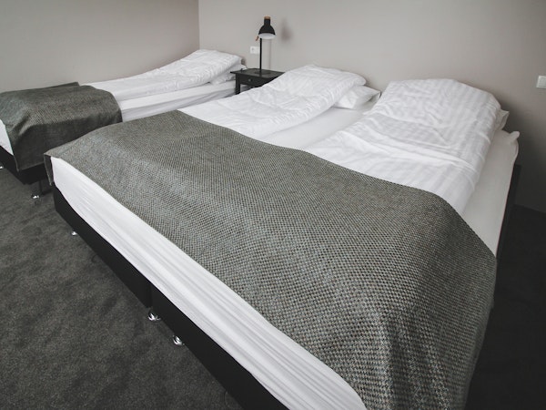 A triple room in Bella Hotel, with one single bed and one double bed.