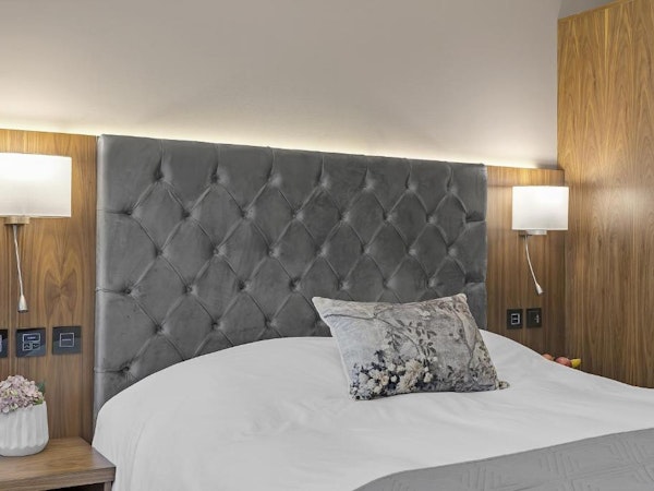 Close-up of a luxurious headboard and bed at the Alva Hotel.