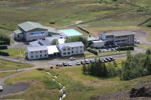 A birdseye view of Dala Hotel with cars parked in front and countryside surroundings.