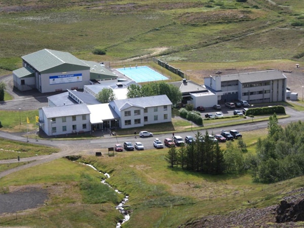 A birdseye view of Dala Hotel with cars parked in front and countryside surroundings.