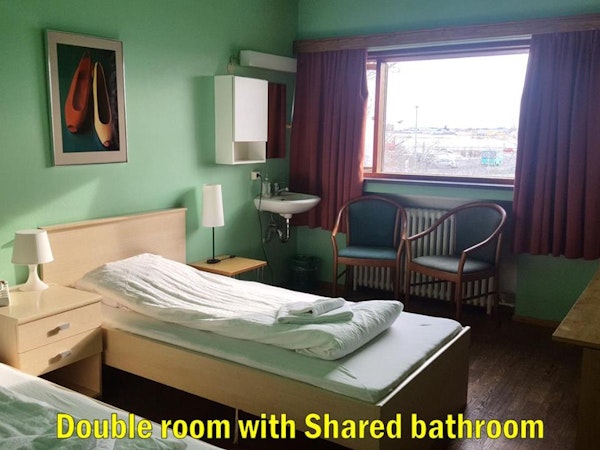 Travel Inn Guesthouse offers a double room with two twin beds, an in-room sink, and a shared bathroom.