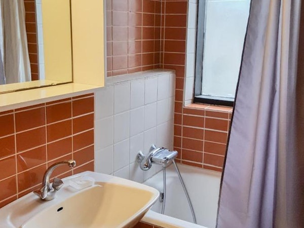 Travel Inn Guesthouse offers bathrooms with bathtubs, showers, sinks, and toilets.