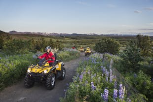 ATV riders enjoy traversing the rugged trails alongside Lake Hafravatn, surrounded by beautiful scenery.