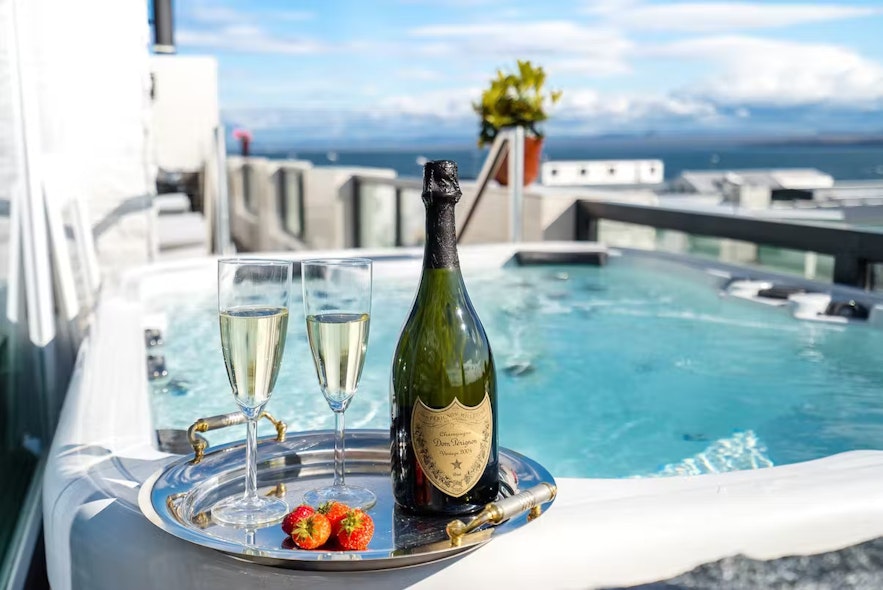 A bottle and two flutes of champagne rest on a tray next to the hot tub at the Diamond Suites hotel in Keflavik.
