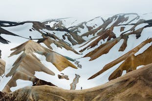 Caramel colored peaks at Landmannalaugar in the Icelandic Highlands are splattered with snow.