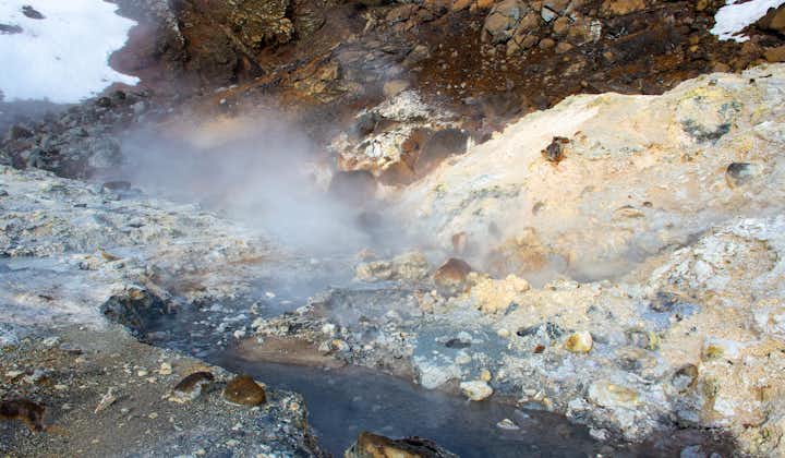 A hot and steaming creek flows through the Krysuvik geothermal area.