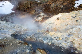 A hot and steaming creek flows through the Krysuvik geothermal area.