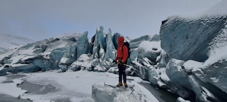 A hiker gazes at the unique ice formations while hiking on the Solheimajokull glacier in Iceland.