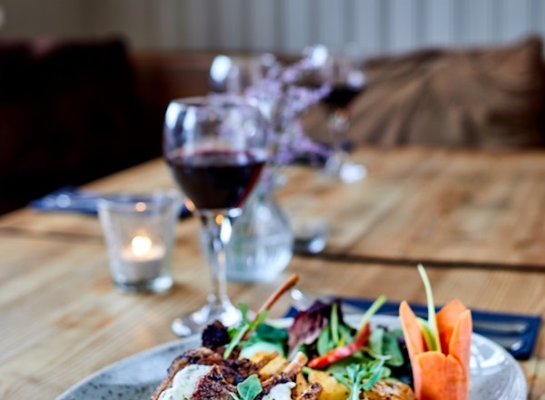 A close-up image of delicious cuisine and a glass of red wine at Englendingavik restaurant in Borgarnes.