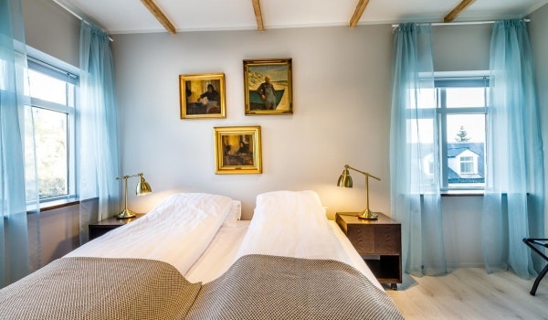 A cozy double room at Englendingavik with bedside tables and lamps.
