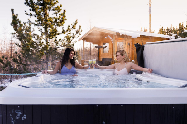 Guests at Kalda Lyngholt enjoy a drink in the outdoor jacuzzi.