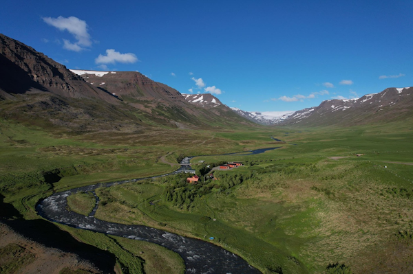 The countryside surrounding Dalasetur is stunning, with a river, mountains, and green pastures.