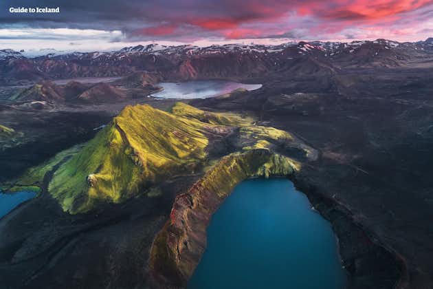 The stunning Blahylur crater lake with bright blue water amid the jagged mountain ranges in the Icelandic Highlands.