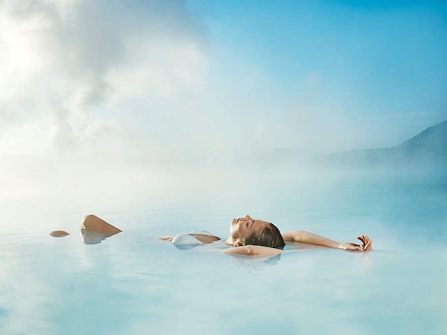 En kvinne slapper av i vannet i Den Blå Lagune