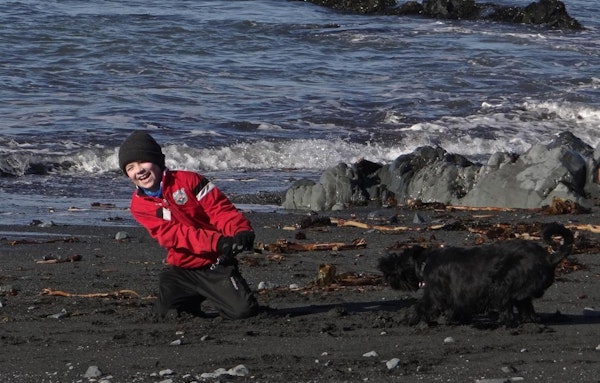 A boy plays on a black-sand beach near Esjan, a glamping experience near Reykjavik.