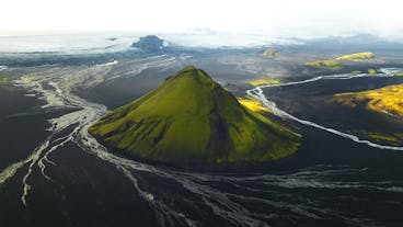 Maelifell volcano has a striking cone shape, and its green slopes contrast amazingly with the black-sand deserts below.