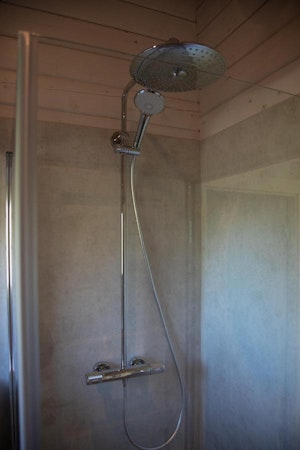 A close-up view of the shower head in the walk-in shower in one of the Dalasetur cabins.