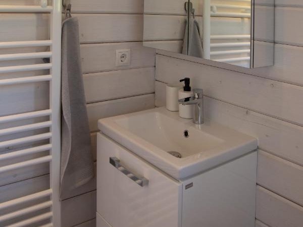 A sink with soap, a mirrored cabinet, and a heating rack in a bathroom at Dalasetur.