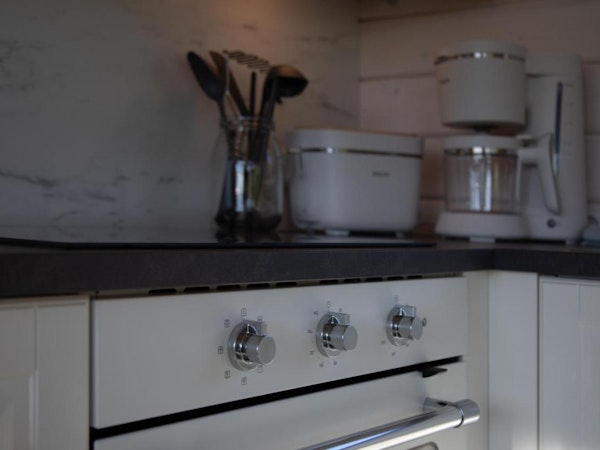 A close-up view of the oven dials and other modern kitchen appliances in one of the cabins at Dalasetur.