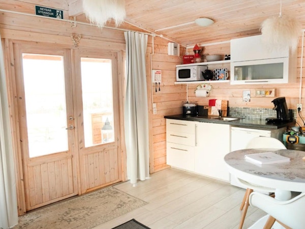 The kitchenette in your cabin at Kalda Lyngholt is well-equipped, with a microwave, stove, fridge, and kitchenware.
