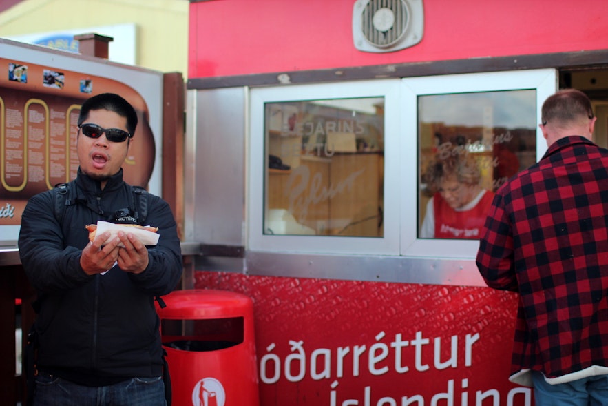 A traveler enjoying their order from Iceland's most popular hot dog stand.