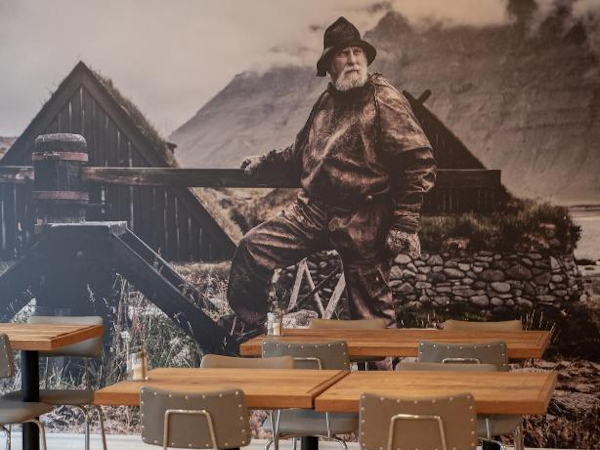 Local artwork adorns the entire wall of the dining room at the Fisherman Guesthouse Sudureyri in the Westfjords.